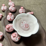 Grisfigur i keramik med blomma