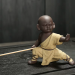 Kung fu-munk som tea pet i violett lera — 1 figur, låg ställning med särade ben, ockragul