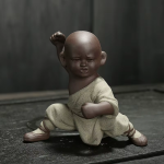 Kung fu-munk som tea pet i violett lera — 1 figur, på huk med höjd knytnäve, grönbeige