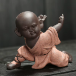 Kung fu-munk som tea pet i violett lera — 1 figur, på knä med en arm lyft, laxrosa