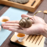 Tea pet i lila lera med upphöjd spiral