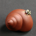 Tea pet i lila lera med upphöjd spiral