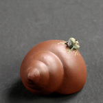 Tea pet i lila lera med upphöjd spiral