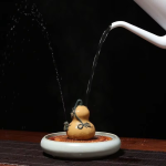 Tea pet i lila lera med vattenstråle
