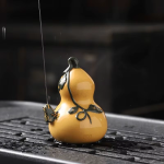 Tea pet i lila lera med vattenstråle — Gulorange kalebass