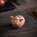 Tea pet med tjurmotiv av lila lera