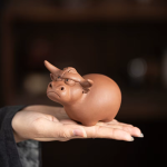 Tea pet med tjurmotiv av lila lera