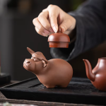 Tea pet med tjurmotiv av lila lera